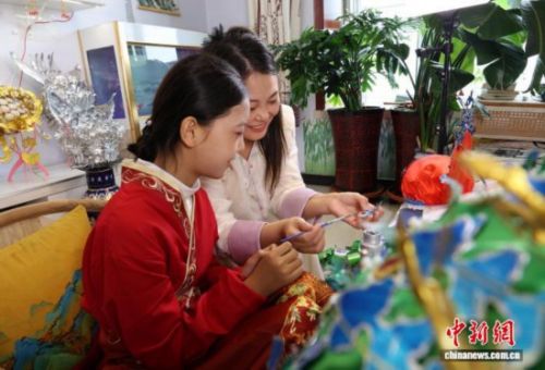 图为王媛娇和女儿一起制作凤冠。夏晓婷 摄