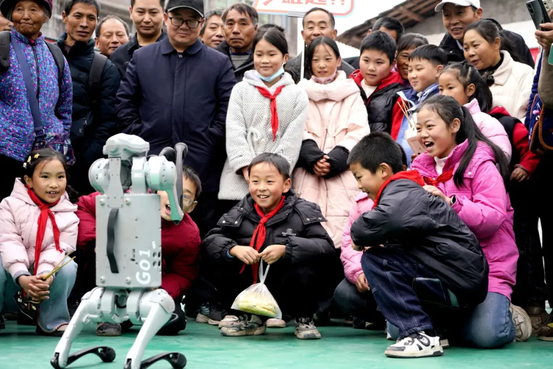 2025年12月6日，四川省巴中市通江县胜利乡新时代文明实践所，学生们与机器狗开展一场别开生面的“人机互动”活动。 程聪 摄