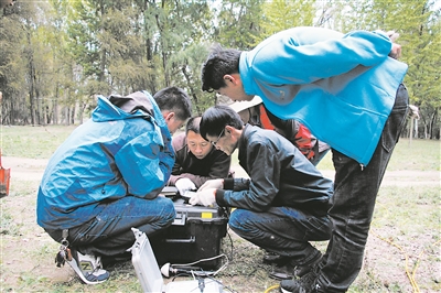 甘斌（左二）与物探技术人员在开展大深度地热探测试验。  受访者供图