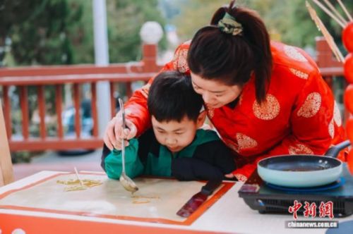 图为小朋友体验糖画制作。翁榕飞 摄