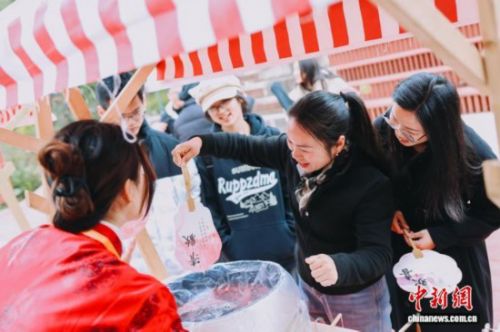 图为游客体验漆扇制作。翁榕飞 摄