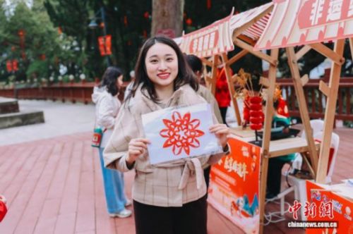 图为游客展示剪纸作品。翁榕飞 摄