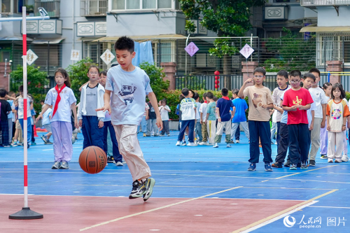 2026年5月27日,浙江杭州长寿桥小学的孩子们在操场上打篮球。奔跑、传球、投篮,笑声与脚步声交织成一片。人民网记者 郭扬摄