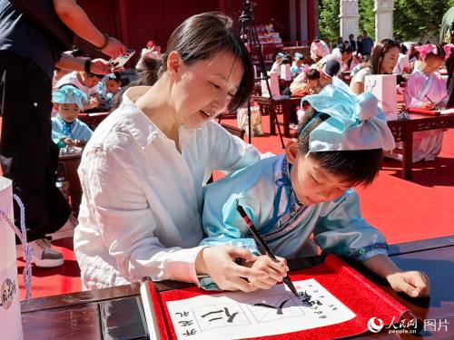 2026年5月30日,在吉林长春文庙博物馆传统启蒙礼活动现场,孩子们提笔书写“仁”与“人”,在古韵雅乐中笃学明礼,开启崭新的成长篇章。人民网记者 王帝元摄