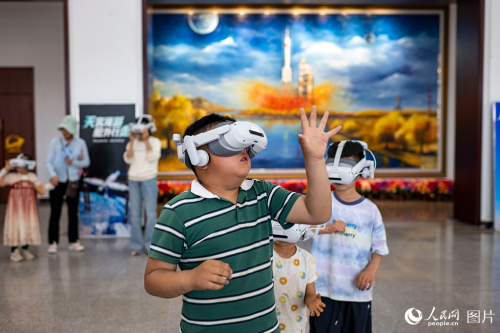 2026年5月23日,在酒泉卫星发射中心的科普活动现场,孩子们正通过VR设备体验太空探索,感受星辰大海的壮阔。人民网记者 翁奇羽摄