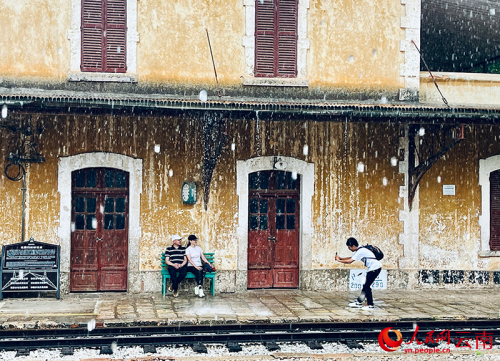 【3】游客雨中打卡碧色寨景区。人民网记者-程浩摄