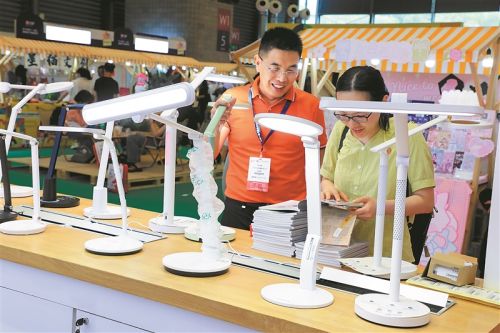 参观者在中国文化用品商品交易会挑选护眼灯。